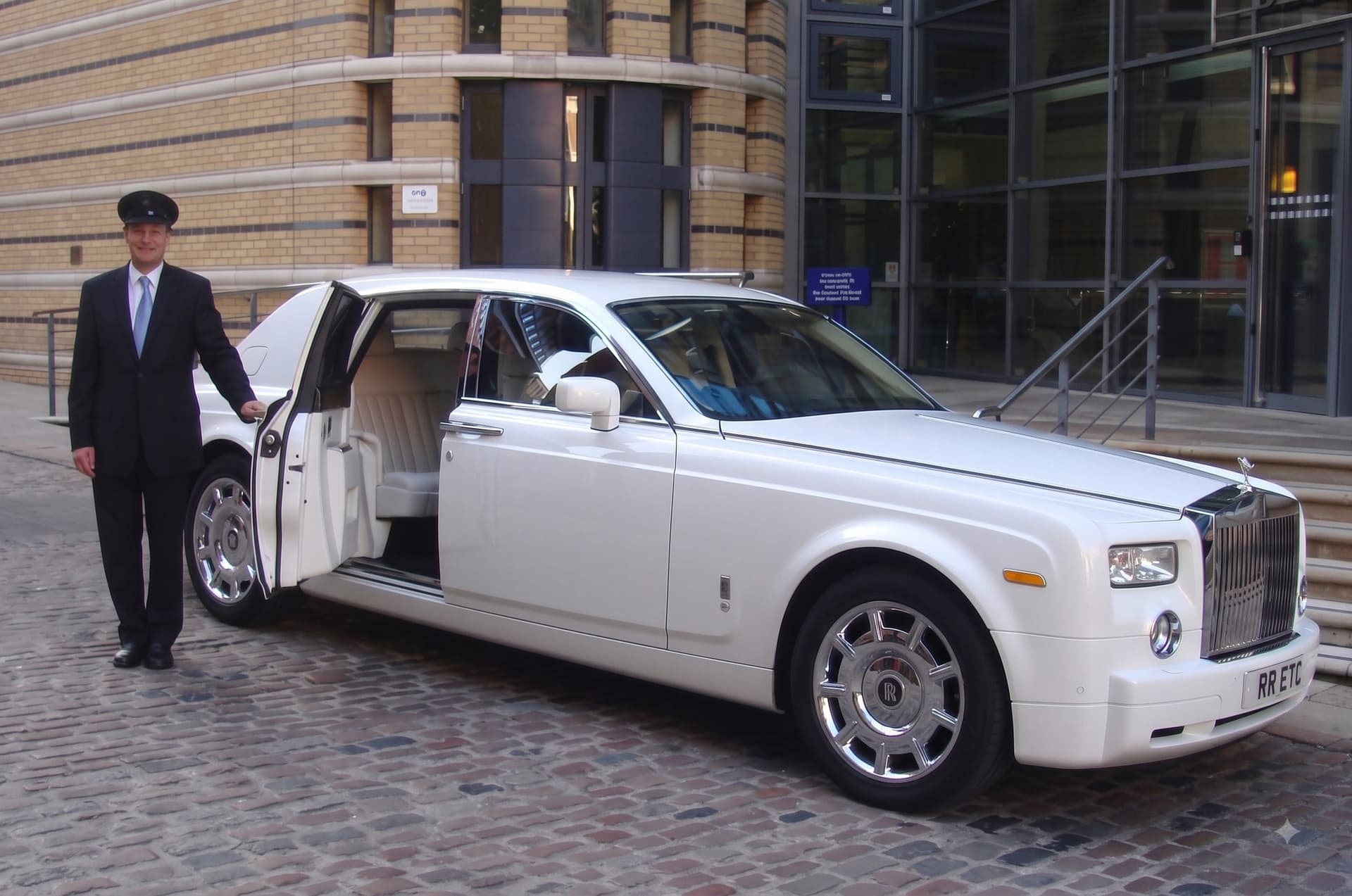 Chauffeur LuxuriaCar ouvrant la portière de la Rolls-Royce Phantom